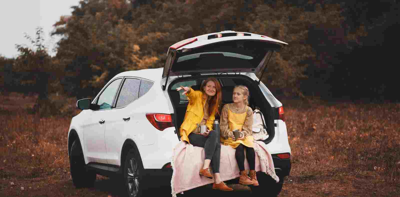 mom and daughter sitting in back of car