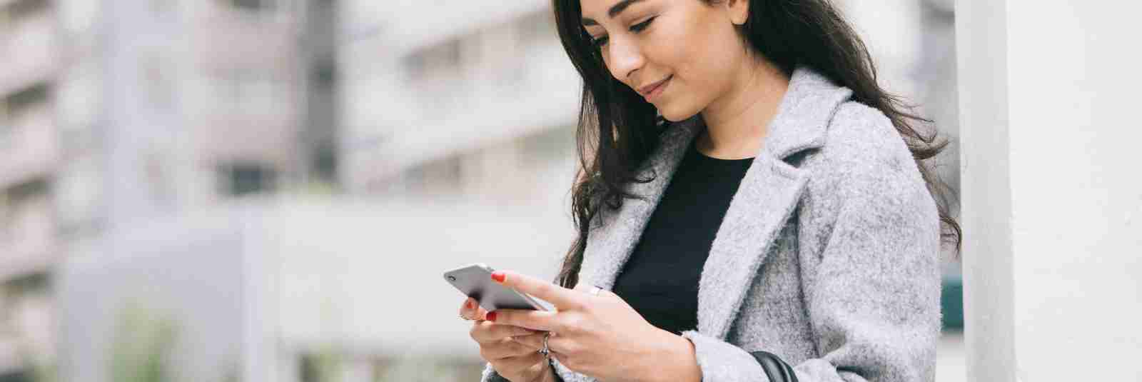 woman outside looking at her phone