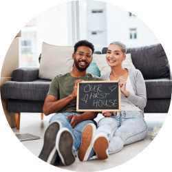 couple holding first home sign in living room