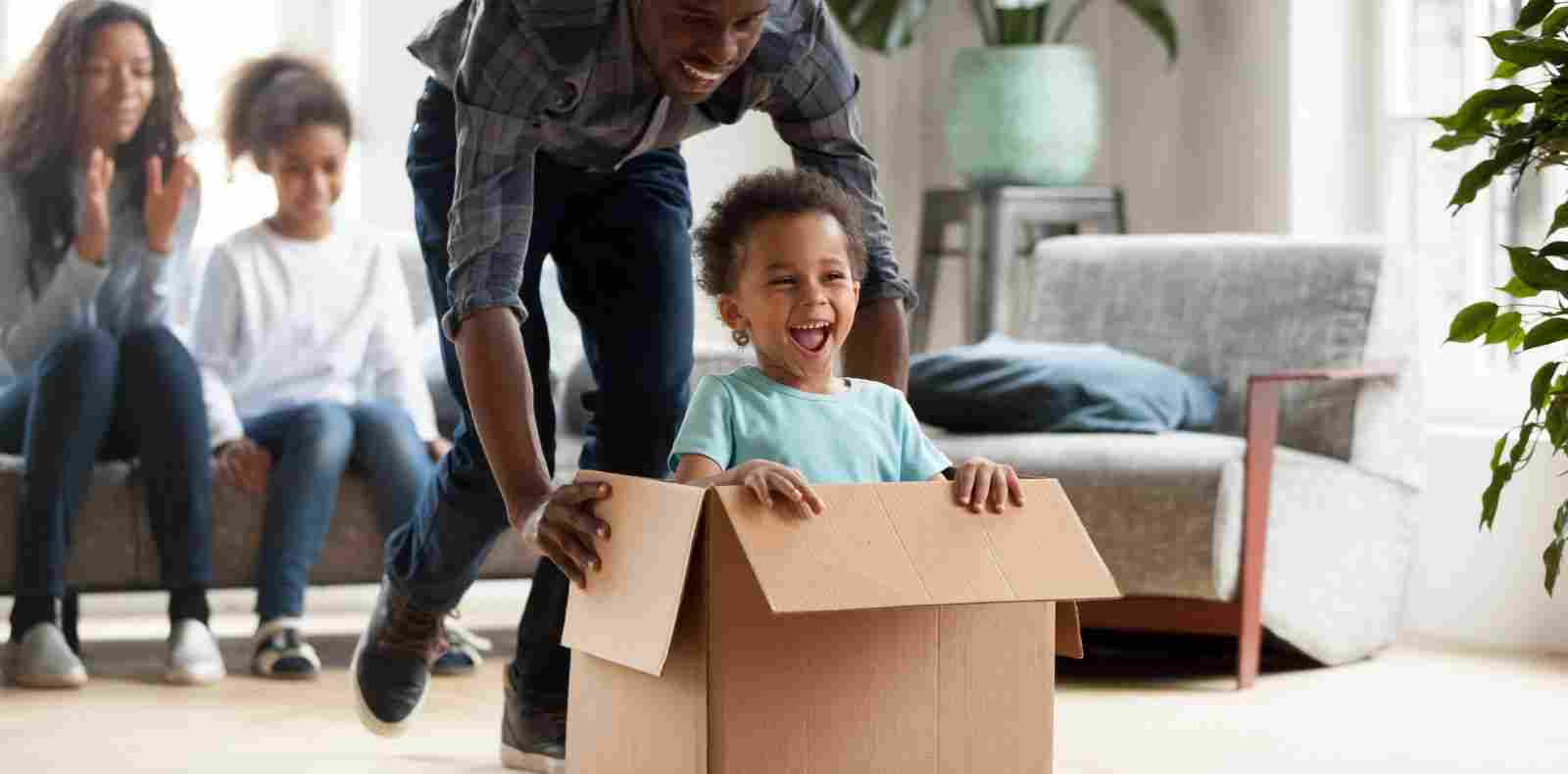 dad playing with kid in moving box