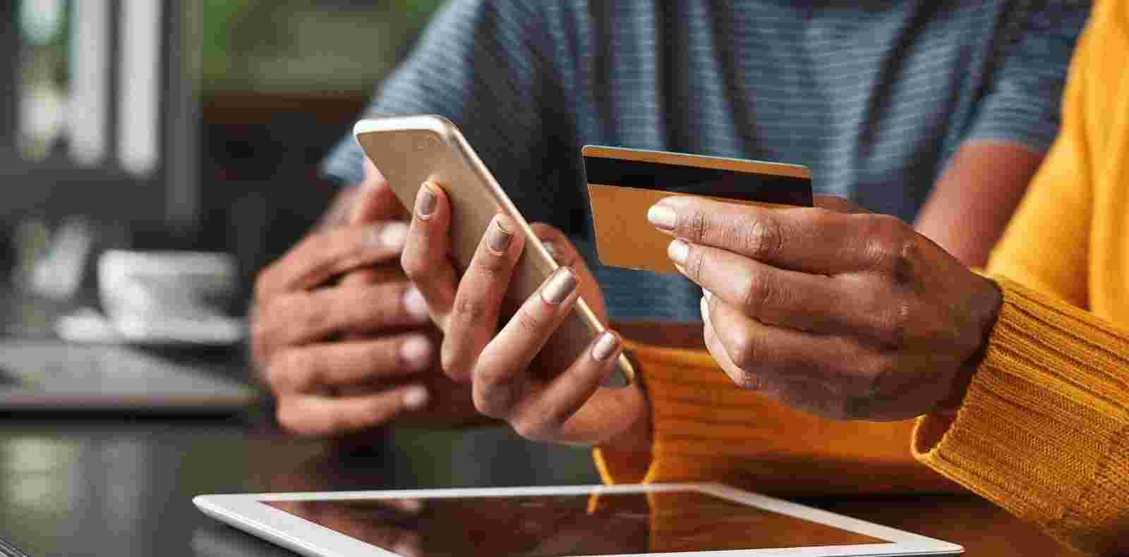 woman using her phone and credit card