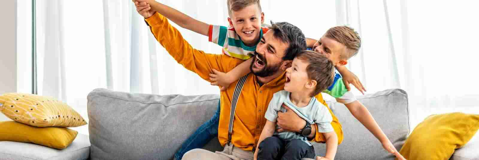 father and three boys on couch