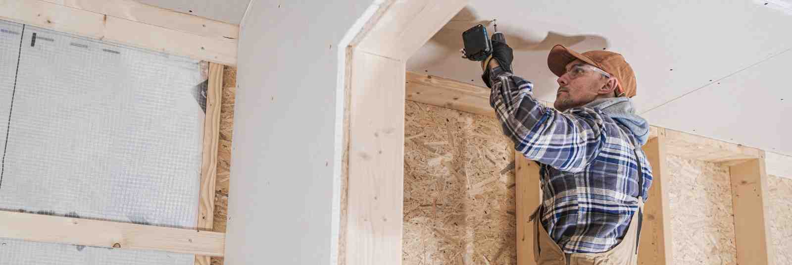 man drilling ceiling home construction