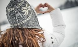 woman with winter hat makgin a heart with her hands