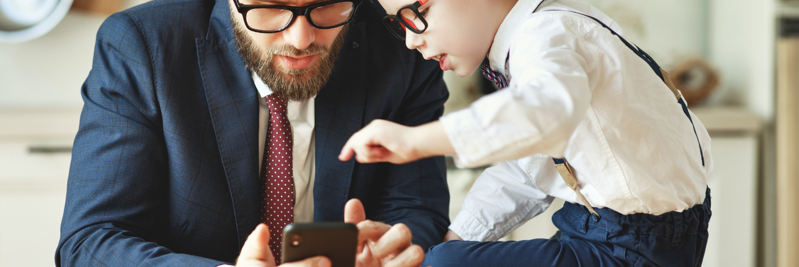 a son teaching his dad how to use a smart phone