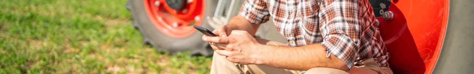 man farming and working on his phone