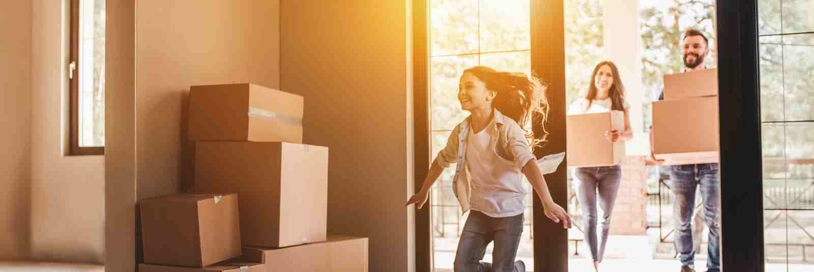 Girl running into new home parents behind her