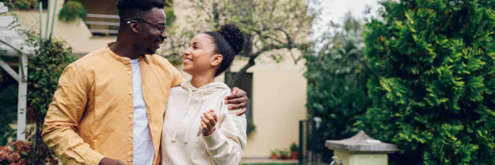 Couple standing in front of new home