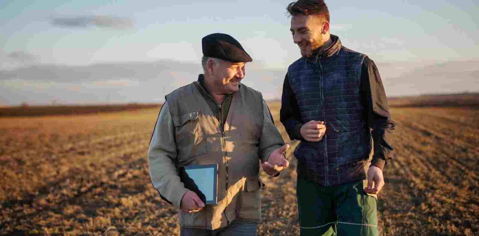 two men pleasantly talking in field