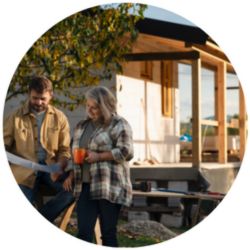 couple reviewing blue prints in front of home under construction