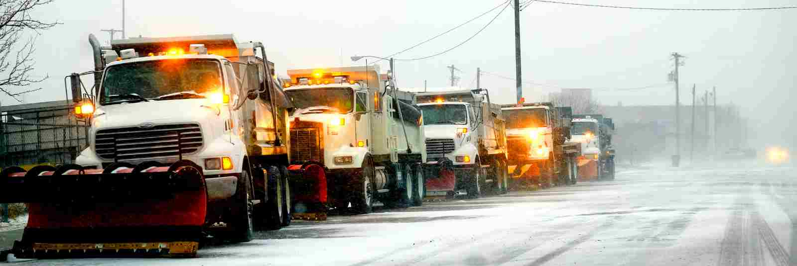 Snow plows lined up on winter street