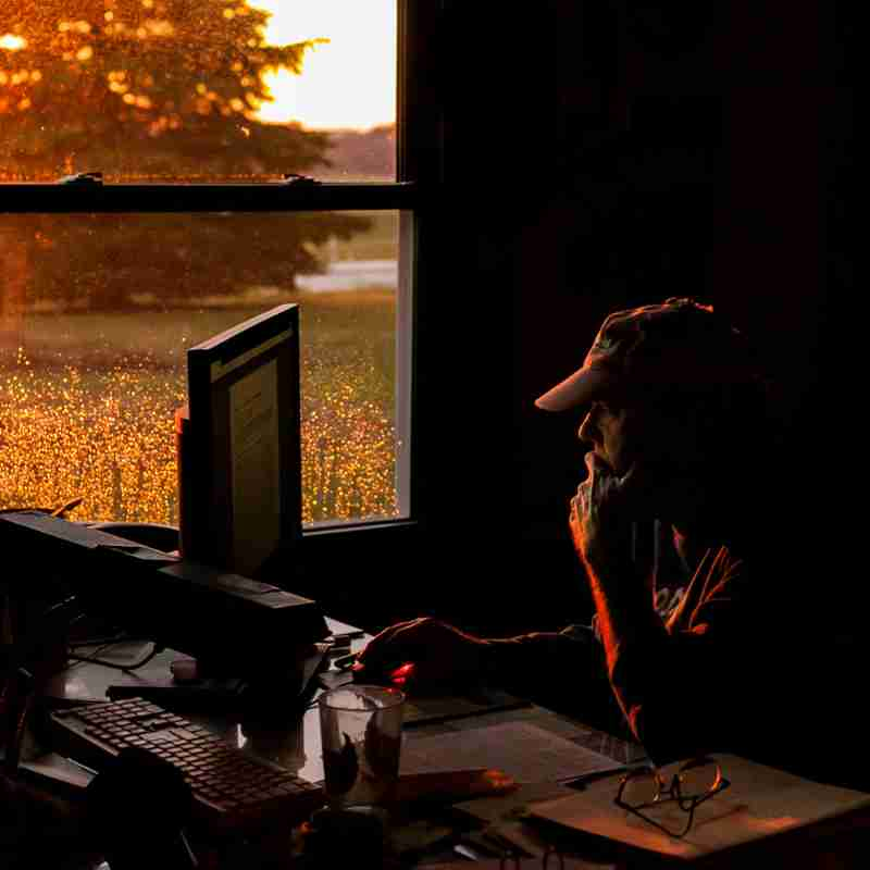 farmer doing paperwork inside during sunset